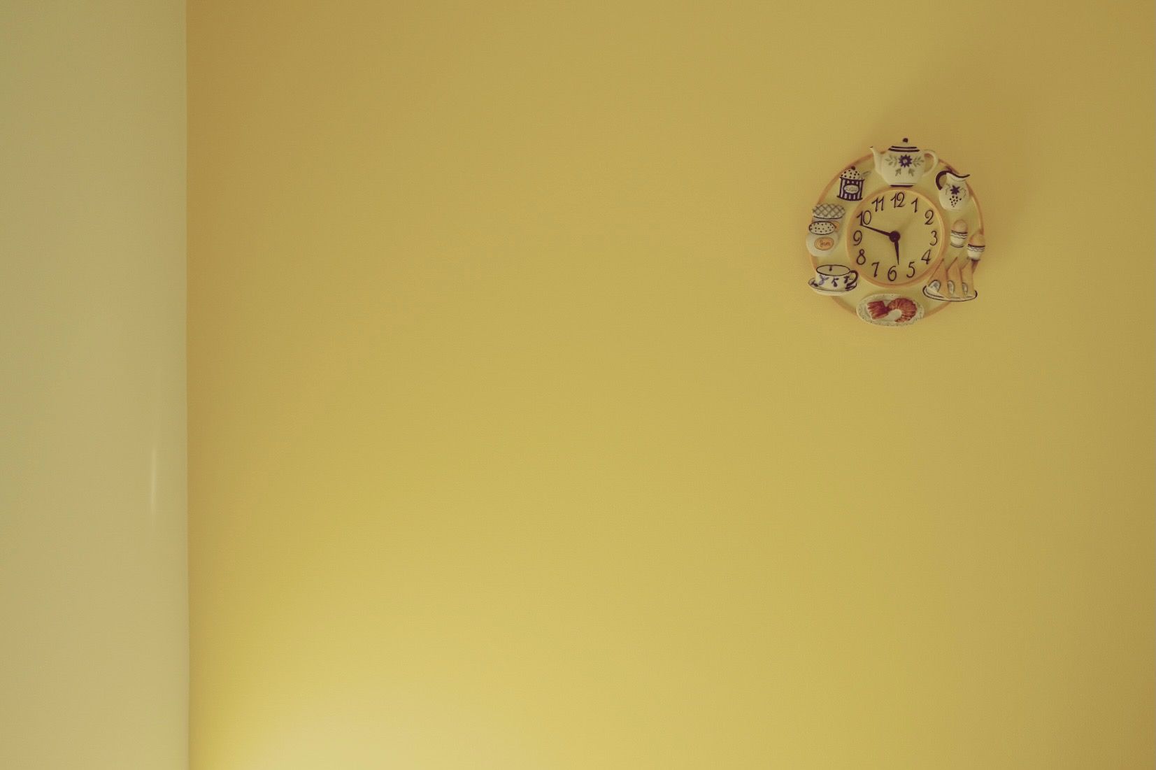 A breakfast themed clock set on a bright yellow wall.